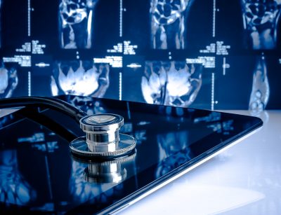 Medical Stethoscope On Modern Digital Tablet In Laboratory On X-ray Images Background